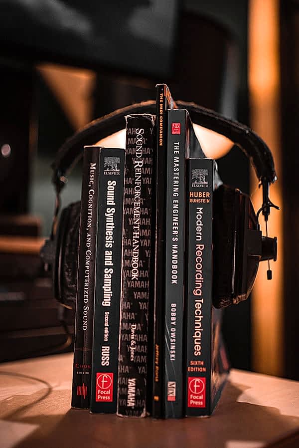 Audio Book recording photo. A stack of audio books wearing headphones.